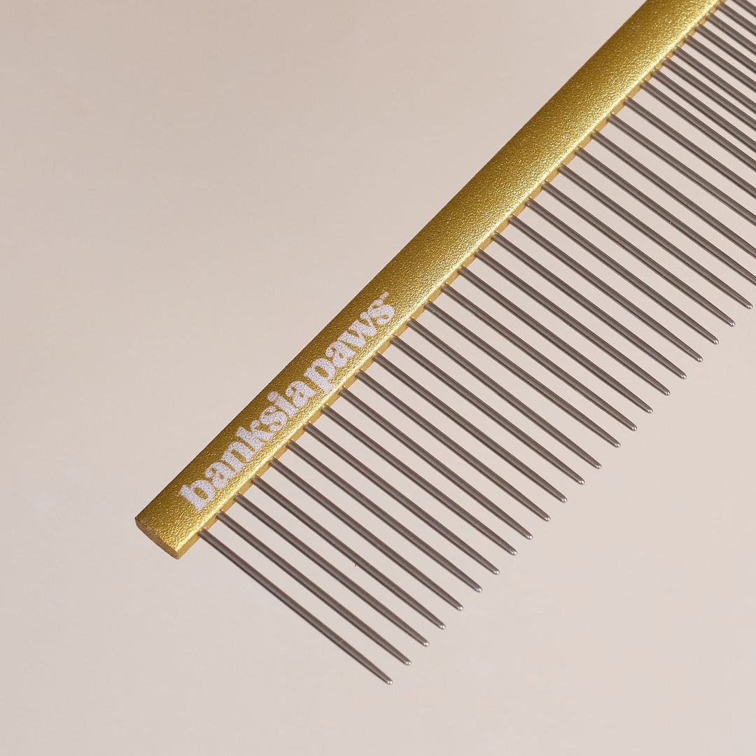 Gold comb with 'Banksia Paws' branding on a beige background
